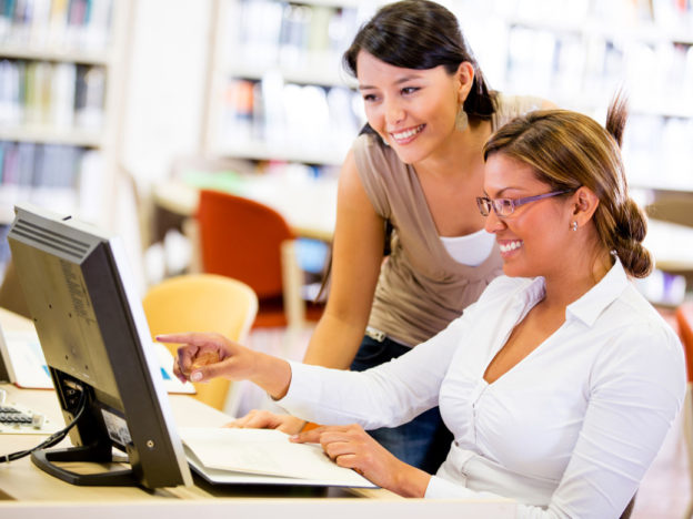 2 people sitting at computer
